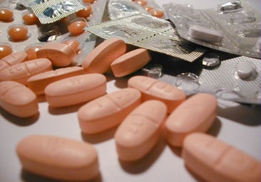 Prescription pills and packets on a table.