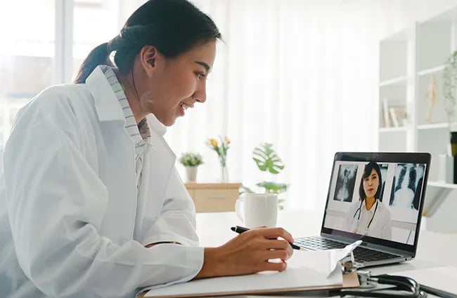 Woman watching a health professional presenting on a laptop