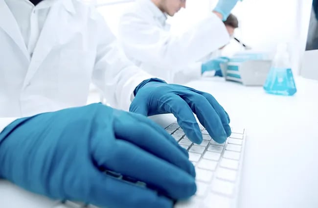 health-care-worker-with-latex-gloves-typing-on-keyboard-ss-1322036018-650x425