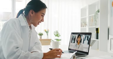 Health care professional meeting virtually with another healthcare professional