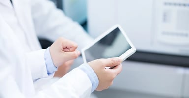 Healthcare workers sharing a tablet device data with a coworker