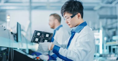 Person in lab coat investigating a medical device