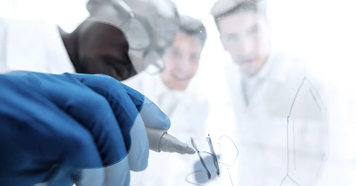 Health care providers writing on clear whiteboard